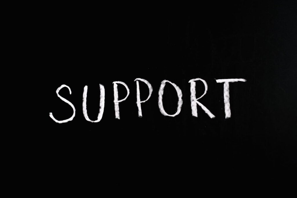 Chalkboard with the word 'Support' written in white chalk on a black background.