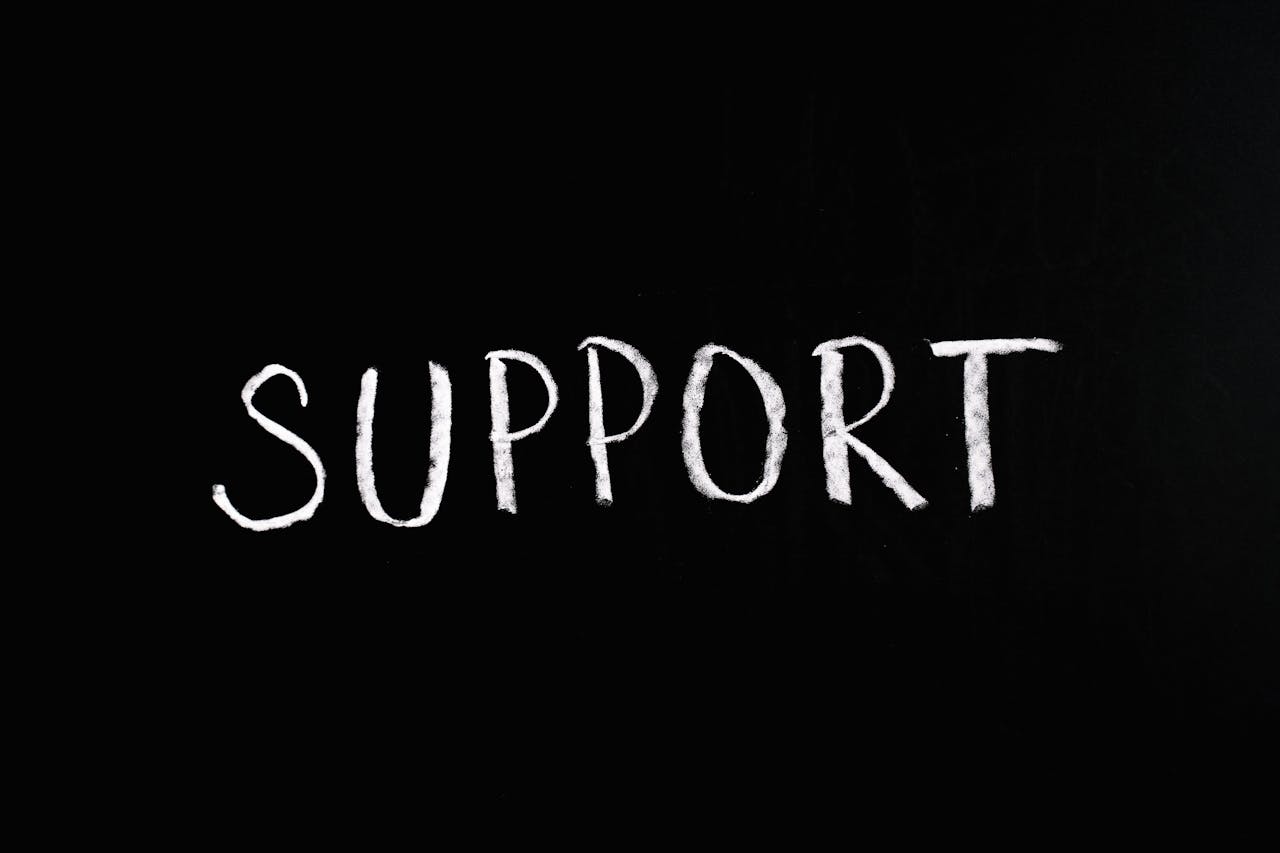 Chalkboard with the word 'Support' written in white chalk on a black background.